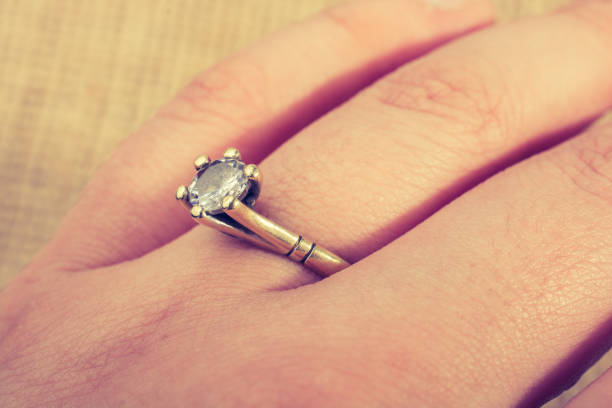 istock Hand wearing a diamond ring on a textured background 1067328826