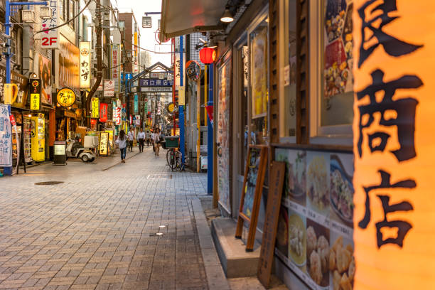 도쿄, 일본-2018 년 8 월 18 일: 전통 나무 랜 턴 및 야마노테 선 간다 역 서쪽 출구에서 쇼핑 거리의 블루 금속 입구 게이트. 거리 300 미터 이상 확장 하 고는 100 미만 상점, 식당 또는 상술 - pachinko 뉴스 사진 이미지
