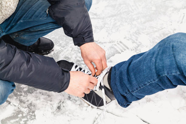 istock Men hands untie string on women skate boot 1067337214
