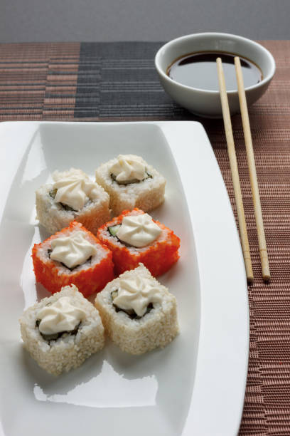 istock Exotically japanese seafood, roll are lying on a white plate. 1067337728