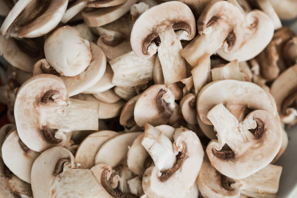 champignons in dünne scheiben schneiden - champignon stock-fotos und bilder