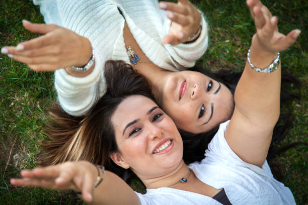 istock Two girls lying on the grass and looking at camera 1067340520