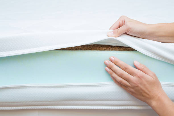 istock Woman's hands touching different layers of new mattress. Checking hardness and softness. Choice of the best type and quality. Front view. Closeup. 1067340572