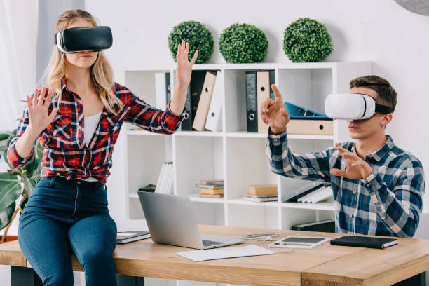 istock young businesspeople in virtual reality headsets gesturing at workplace in office 1067343506