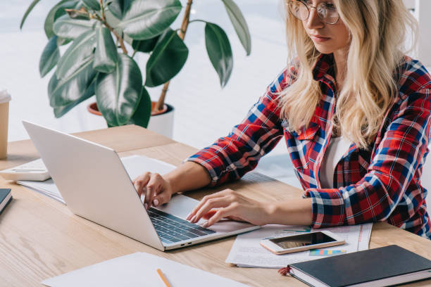 istock focused businesswoman using laptop at workplace with papers 1067343710