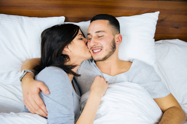 istock Young couple in bed embracing. 1067347544