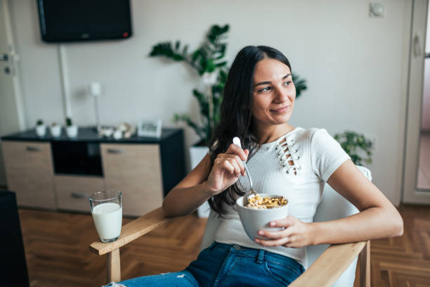 gustare una sana colazione a casa. - eating women breakfast cereal foto e immagini stock