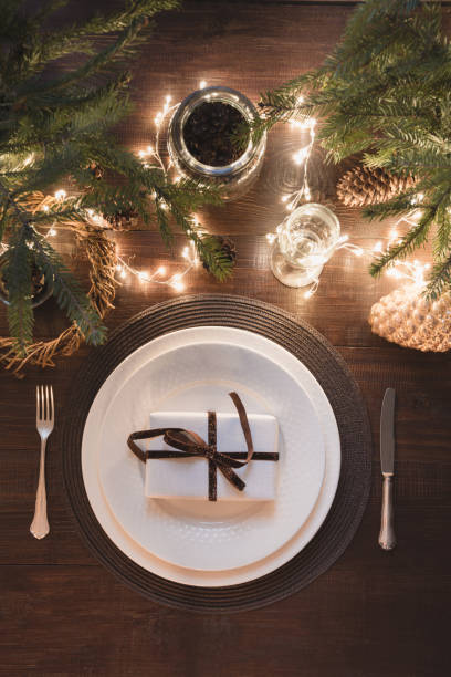 istock Christmas table setting with silverware, garland and dark evergreen decor. Top view. Xmas Party. Magic night. 1067351756
