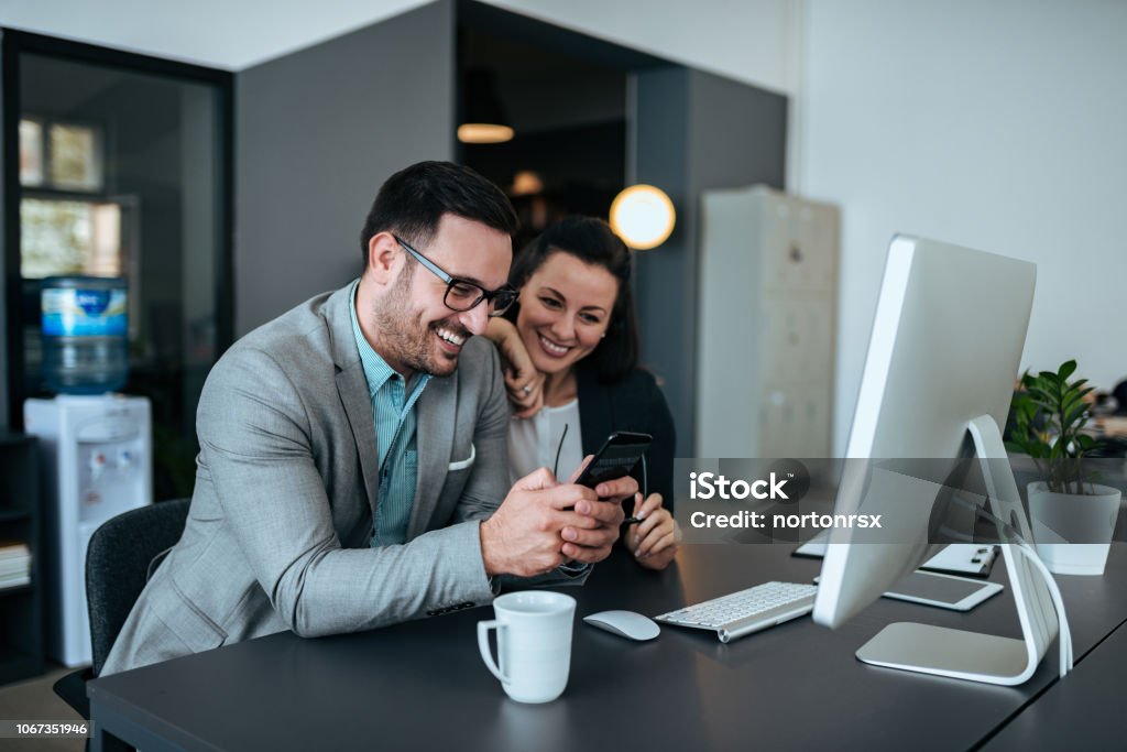 Young happy couple working together in the office. Couple - Relationship Stock Photo