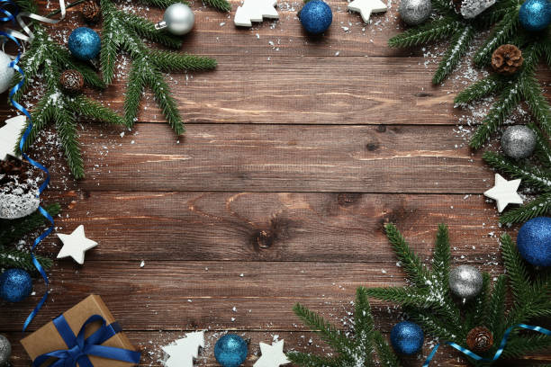 istock Christmas decorations with cones and snow on wooden table 1067352318