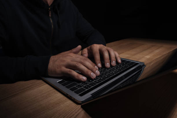 istock cropped shot of hacker using laptop, cuber security concept 1067352332