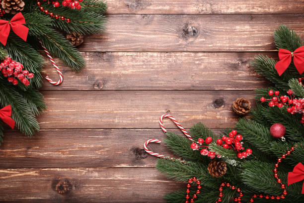 istock Christmas fir tree branches with decorations on brown wooden table 1067353652