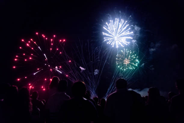 istock New year concept - cheering crowd and fireworks 1067353732