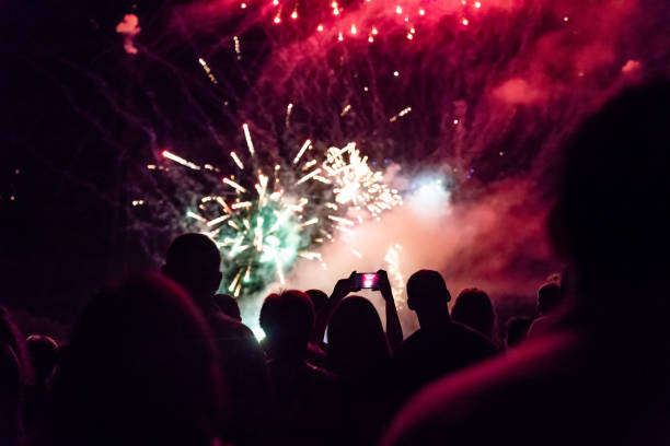 istock New year concept - cheering crowd and fireworks 1067353754