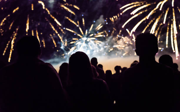 istock New year concept - cheering crowd and fireworks 1067353922