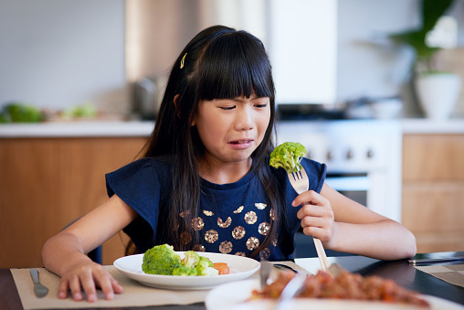 Shot of a little girl refusing to eat her broccoli