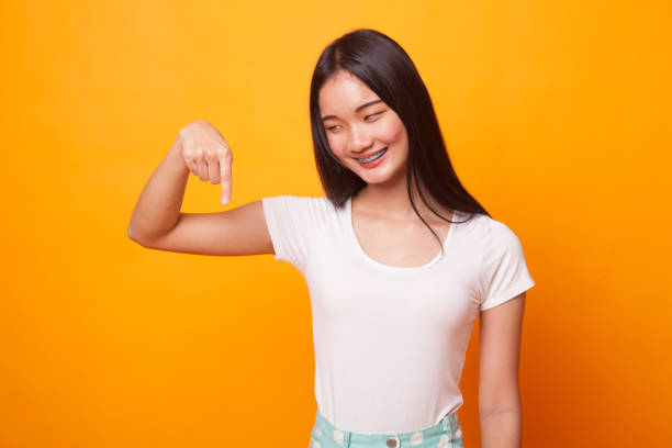 istock Beautiful young Asian woman point down to blank space. 1067357602
