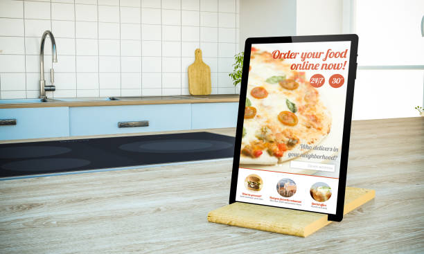 istock tablet pc with order food online screen on cooking island at the kitchen 1067358610