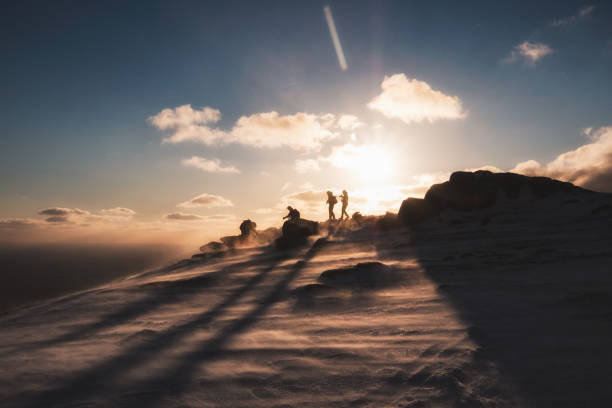 Climbers helping at on top mountain Climbers helping at on top mountain at sunset reach destination stock pictures, royalty-free photos & images