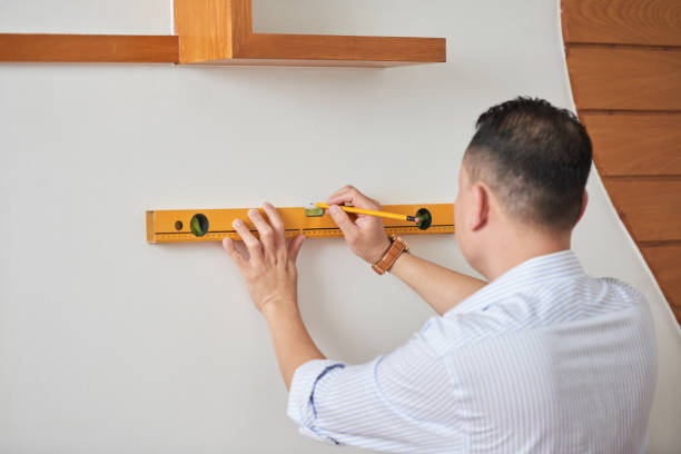 istock Man measuring the wall with level 1067365022