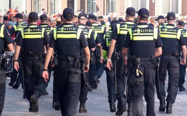 Dutch Police Officers Walking During Prinsjesdag In The Hague South Holland The Netherlands. Europe View Of People Looking Around, Talking To One Another, Taking Picture, Dutch Police Officers In Uniform Walking At Noordeinde Palace During Prinsjesdag, The Day On Which King Willem Alexander Of The Netherlands Addresses A Joint Session Of The Dutch Senate And House Of Representatives To Give The Speech From The Throne Setting Out The Main Features Of Government Policy For The Coming Parliamentary Session In The Hague The Netherlands Europe gun laws stock pictures, royalty-free photos & images