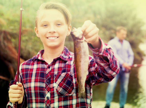 istock Boy holding catch freshwater fish in hands 1067376736