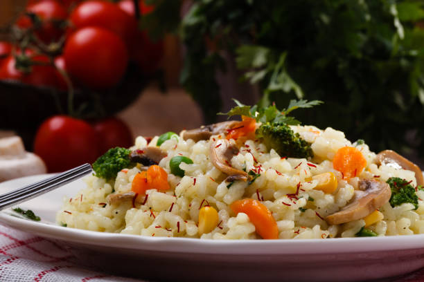 istock Classic Risotto with mushrooms and vegetables served on a white plate. 1067376796