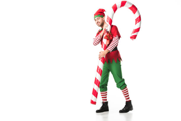 istock man in christmas elf costume carrying big candy cane isolated on white 1067384236