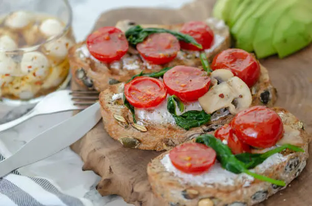 Healthy sandwich with Wholemeal Bread Toast and  with Cream cheese ,green spinach,olive oil mushrooms , avocado and tomatoes,