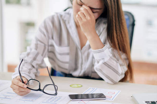 istock Tired woman with eyeglasses at desk 1067397580