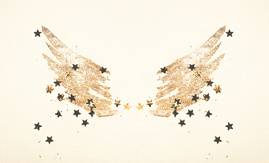 Golden glitter and glittering stars on abstract watercolor wings in vintage nostalgic colors.