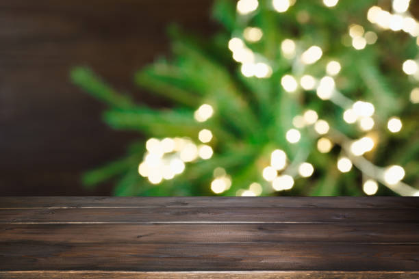 istock Wooden dark tabletop and blurred christmas tree bokeh. Xmas background for display your products. 1067400646