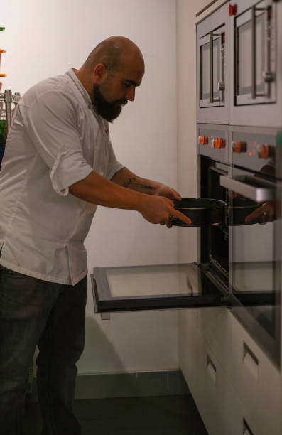 istock Chef is placing cake mold in the oven 1067401360