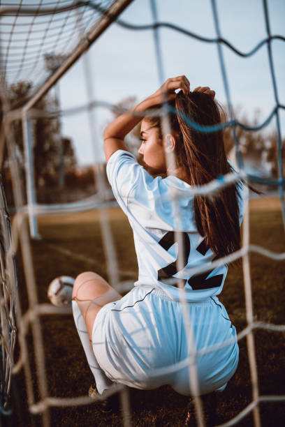 istock Sensual Female Football Player Posing On A Stadium 1067401622