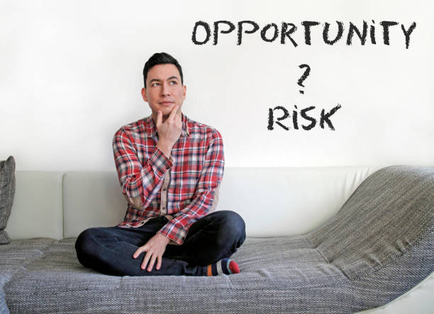 istock Man sitting on couch and contemplating: Risk or Opportunity? 1067403668