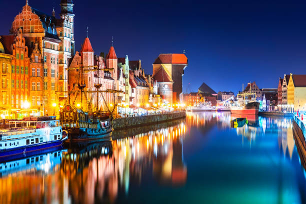 Night view of the Old Town of Gdansk, Poland Scenic night view of the Old Town pier architecture of Gdansk, Poland at the Motlawa River harbor embankment with medieval port crane and historical ships gdansk photos stock pictures, royalty-free photos & images