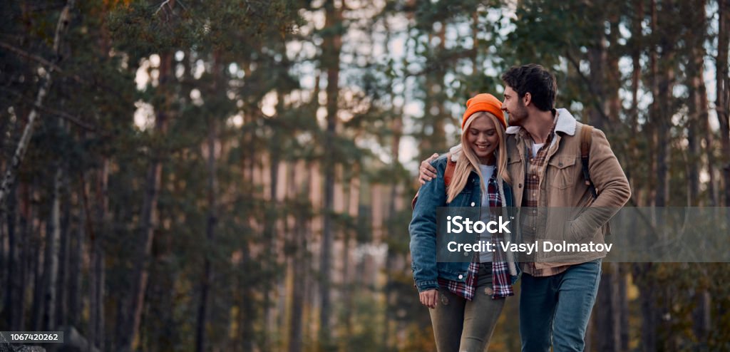 Couple of tourists on nature Young couple of tourists are exploring new places. Attractive young woman and handsome bearded man are spending time together on nature. Couple - Relationship Stock Photo