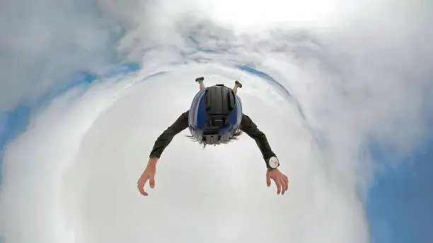 Photo of 360 dregree selfie photo of skydiver above the clouds with camera attached on the helmet