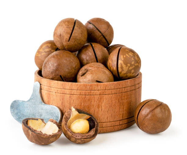 istock Macadamia nuts in wooden plate, key and shell on a white background. Isolated 1067420784
