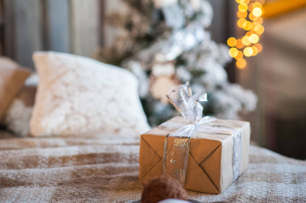 istock New Year's gift on the bed. Scandinavian style bedroom interior under Christmas. Rustic Textured Wooden Bed 1067422116