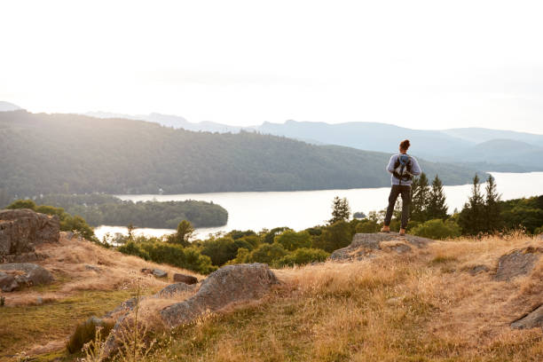 istock A young mixed race man standing alone on rocks, admiring lake view, back view 1067423908