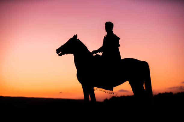 Horses and Men Silhouette at Sunset on a High Mountain Horses and Men Silhouette at Sunset on a High Mountain stampeding photos stock pictures, royalty-free photos & images