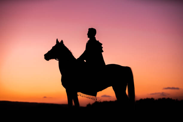 istock Horses and Men Silhouette at Sunset on a High Mountain 1067424322