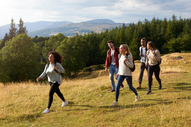 istock A multi ethnic group of five young adult friends smile while walking on a rural path during a mountain hike, side view 1067424402