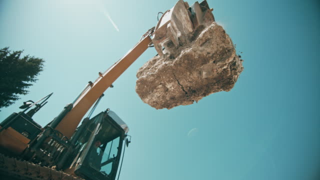 SLO MO Large concrete piece falling down and crushing as the excavator drops it