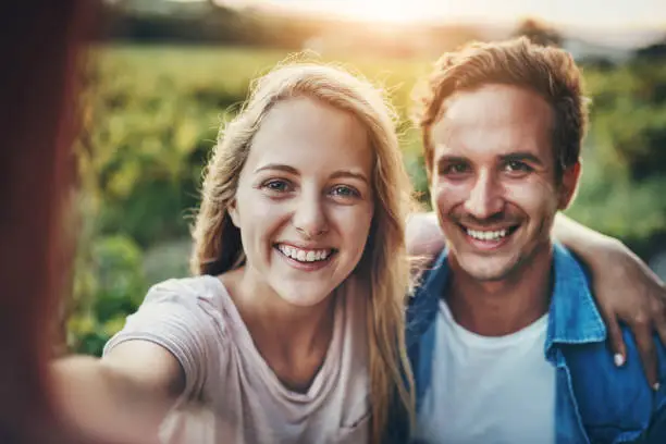 Cropped portrait of a young couple taking a selfie together with their farmland in the background