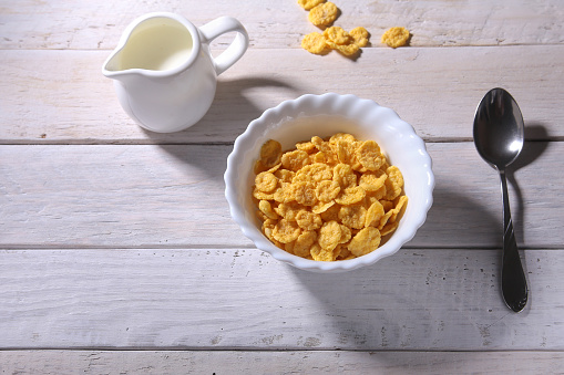 Corn Flakes cereal in a bowl and glass with milk. Morning breakfast