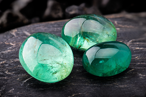 The emerald gemstone jewelry photo with black stones and dark lighting.