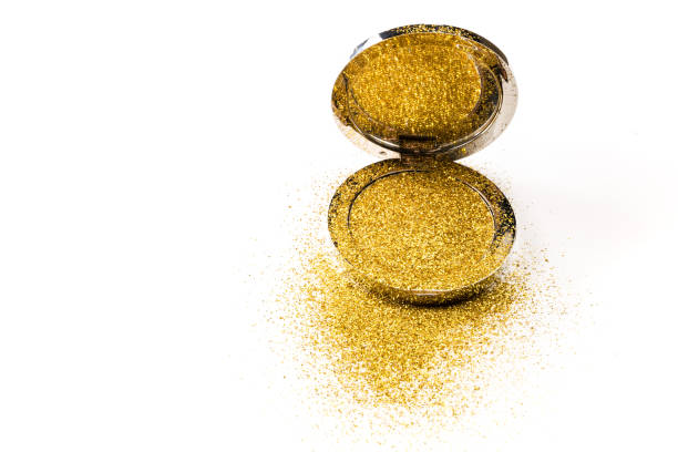 istock Powder highlighter in a silver powder box with gold sparkles reflected in the mirror. Isolated on white background. 1067436546