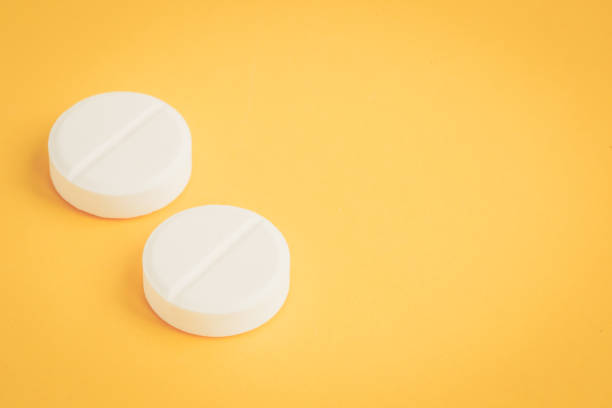 istock WHITE PILLS ON YELLOW BACKGROUND CONCEPT 1067437470
